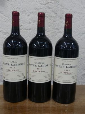 trois bouteilles de vin posées sur une table en bois
