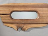 un miroir en bois muni d'une poignée en bois, posé sur une table
