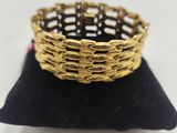 a close up of a gold bracelet on a black pillow