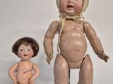 two old dolls that are sitting next to each other