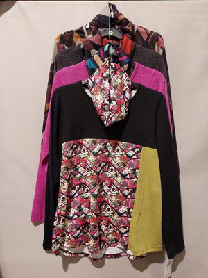 multicolored jacket hanging on a hanger in front of a white wall