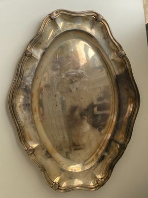 a silver plate on the wall next to a vase
