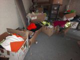 many boxes of clothes in a room with a ladder