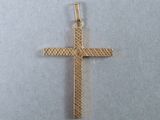 a close up of a gold cross on a white surface