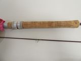 a fishing rod and a pink flower on a table