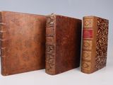 two old books sitting next to each other on a white surface