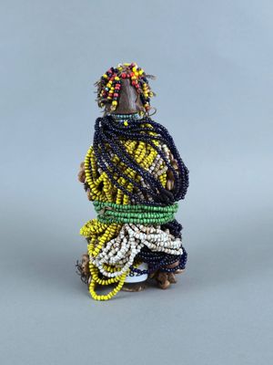 une petite figurine représentant une femme vêtue d'une robe jaune et noire