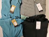 trois vestes pour homme, encore étiquetées, posées sur une table