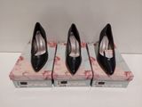 trois paires de chaussures à talons hauts noires posées sur une boîte