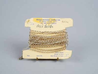 une pile de bracelets en perles d'or et d'argent posée sur un présentoir