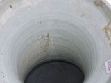 a white vase with a black bottom sitting on a table