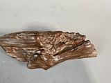 a bronze sculpture of a bird that is on a table