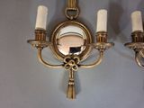 two wall sconces with candles and a mirror on the wall