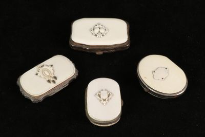 four white porcelain pill cases sitting on top of a black surface