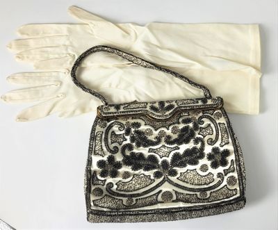 un vieux sac à main et des gants posés sur une table