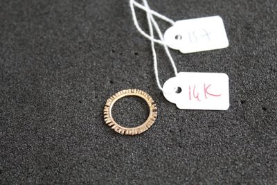 une bague à laquelle est accrochée une étiquette, posée sur une table