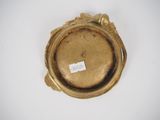 an antique gold plate with a label on it on a white surface