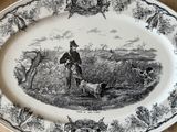 une assiette en noir et blanc sur laquelle figure l'image d'un homme et d'un chien
