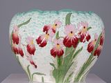 un vase décoré de fleurs, posé sur une table