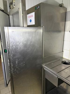 a stainless steel refrigerator next to a sink in a kitchen