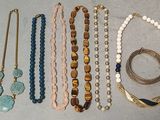 de nombreux colliers et bracelets différents disposés sur une table