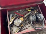 a red box with tools in it sitting on the ground