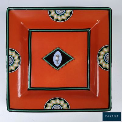 une assiette orange ornée d'un motif en noir et blanc