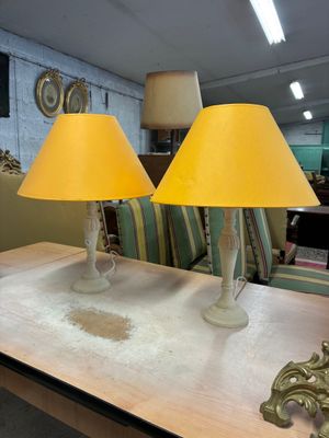 deux lampes posées sur une table dans une pièce où l'on aperçoit un canapé à l'arrière-plan
