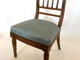 une chaise en bois avec une assise bleue posée sur un sol blanc