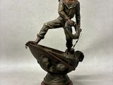 bronze statue of a man on a boat with a dog on it