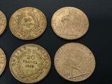 six different types of gold coins sitting on a black surface