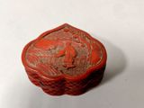 une image représentant une boîte rouge sur laquelle figurent les portraits d'un homme et d'une femme
