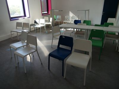 many chairs and tables in a room with a large window