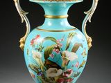 un vase bleu sur lequel sont peints un oiseau et des fleurs