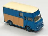 un petit camion jouet bleu et beige posé sur une surface blanche
