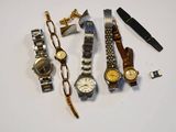 a lot of watches and a pen sitting on a table