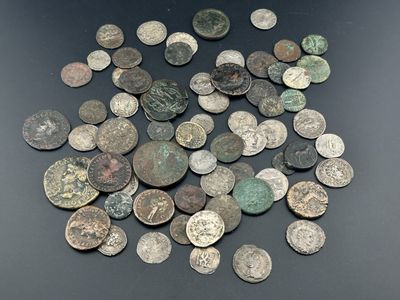 quelques pièces très anciennes posées sur une table noire, sur fond noir