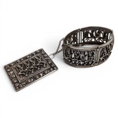 pair of antique silver bracelets and a pendant on a white background