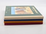 three books stacked on top of each other on a white surface