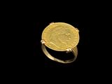a close up of a gold ring with a coin on it