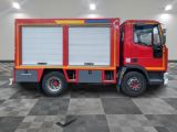 a red and yellow fire truck parked in a room