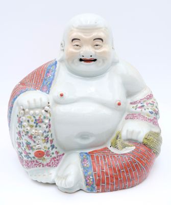 a figurine of a laughing buddha sitting on a pillow