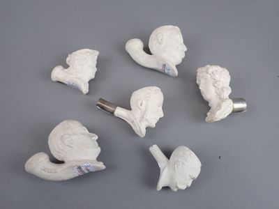 plusieurs figurines en céramique blanche de formes et de tailles variées, posées sur une surface grise