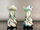 pair of multicolored glass vases sitting on a black surface