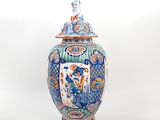 a blue and white vase with a bird on top of it