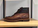 des bottes en cuir marron posées sur une étagère dans un magasin de chaussures