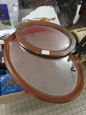 a mirror sitting on top of a table with a pair of scissors next to it