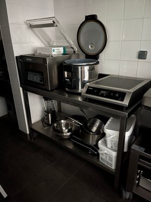 une cuisine équipée d'une cuisinière, d'un micro-ondes, ainsi que de casseroles et de poêles posées dessus