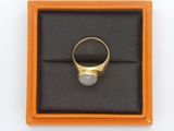 an image of a gold ring with a white stone in a box