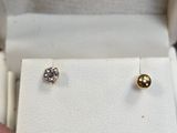 un gros plan sur la main d'une personne tenant une paire de boucles d'oreilles